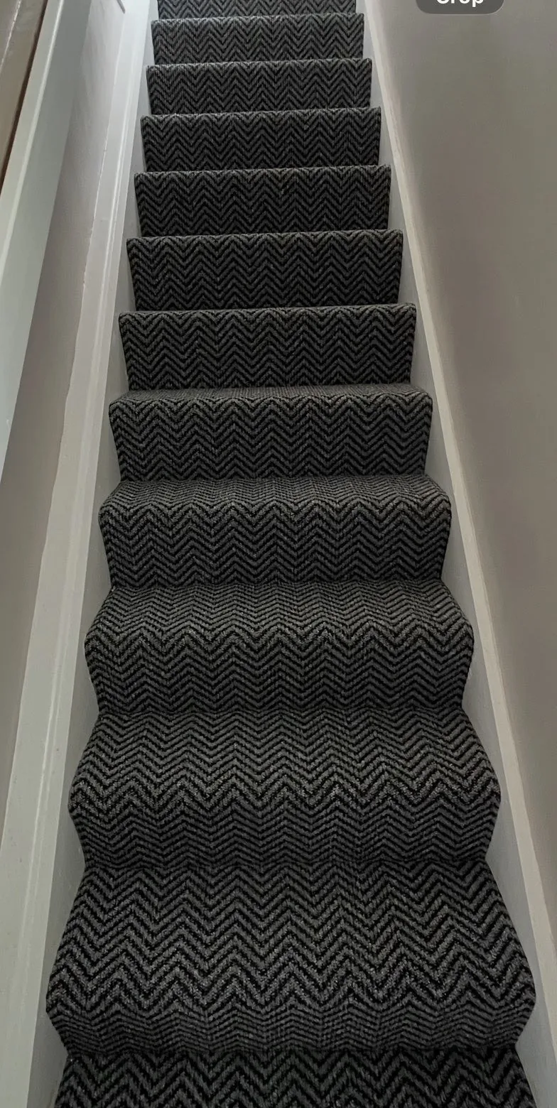 Dark grey carpet fitted on a straight staircase