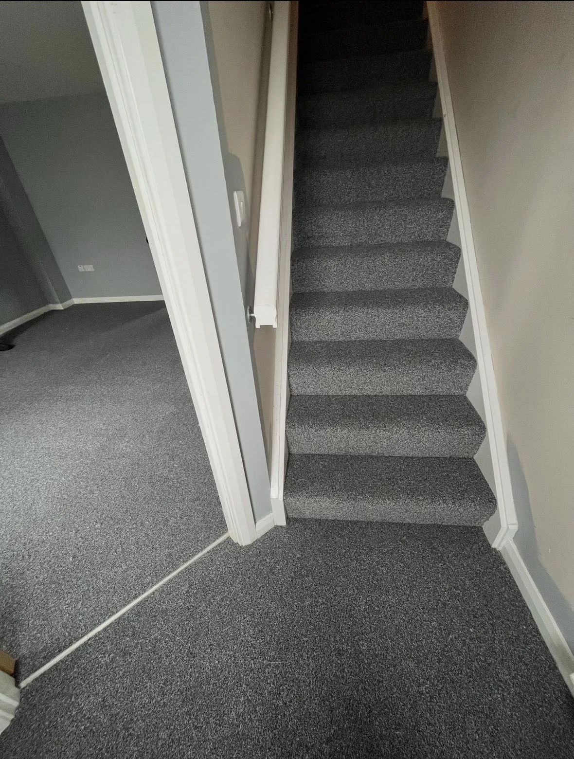 Grey carpet fitted across a hallway and stairs